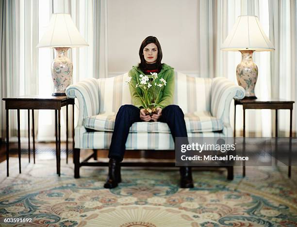 woman sitting with flowers - tweezits bankje stockfoto's en -beelden