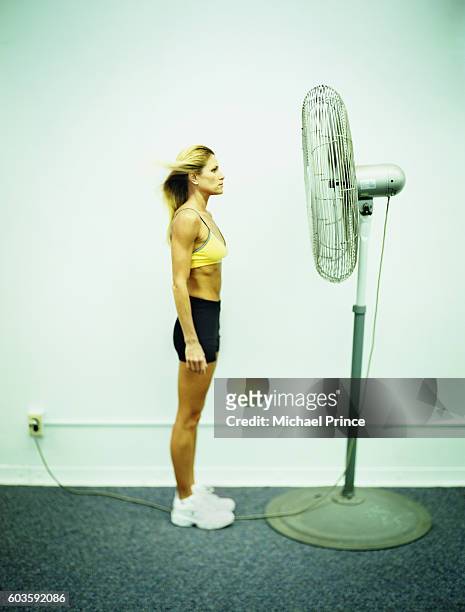 woman standing in front of fan - white spandex shorts stockfoto's en -beelden