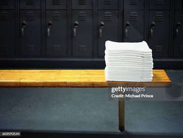 towels on locker room bench - umkleideraum stock-fotos und bilder