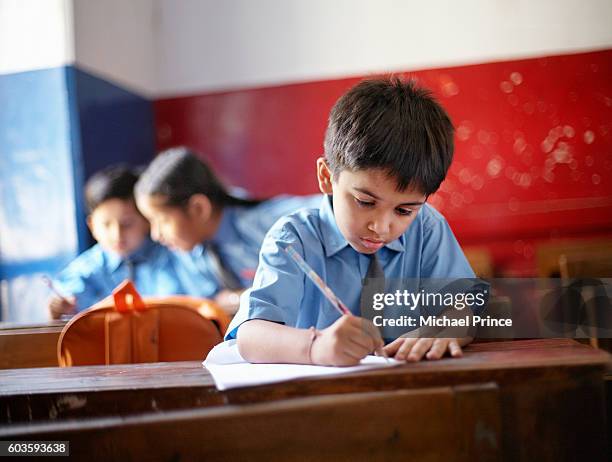 boy writing in class - indian school kids stockfoto's en -beelden