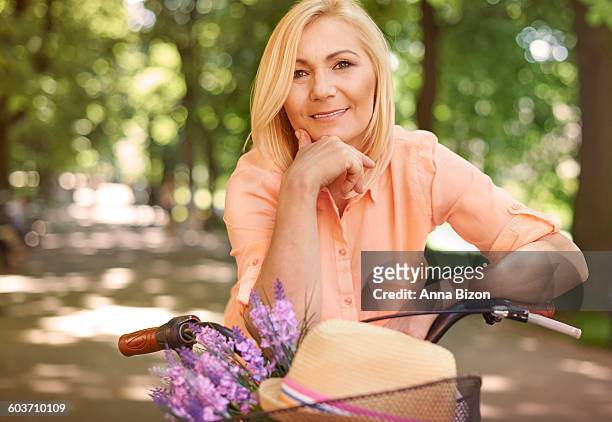 happy mature woman on the bike. krakow, poland - krakow park stock pictures, royalty-free photos & images