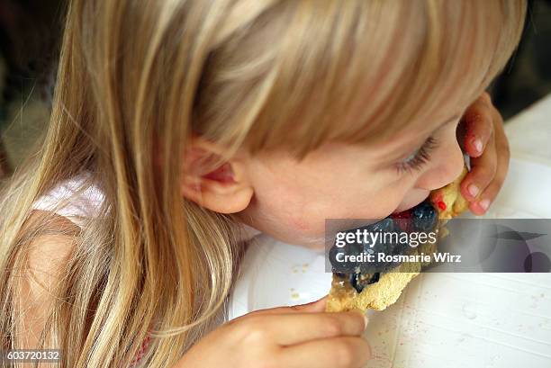 four years old girl eating fruit tart - child yoga elevated view stock pictures, royalty-free photos & images