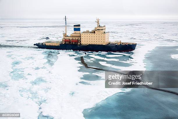 areal shot of ice breaker heading in ne passage - ice breaker stock pictures, royalty-free photos & images