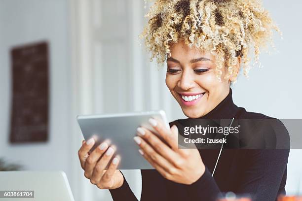 afro amerikanische junge frau mit digitalen tablet in einem büro - e reader stock-fotos und bilder
