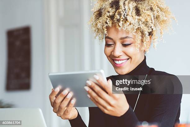 joven afroamericana usando tableta digital en una oficina - email marketing fotografías e imágenes de stock