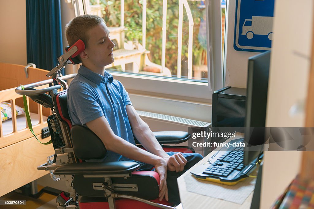 Young disabled man playing computer game