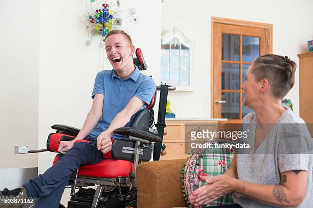 happy young als patient with his mom - physical disability stock pictures, royalty-free photos & images