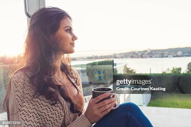 woman drinking coffee at sunrise. - australian winter stockfoto's en -beelden