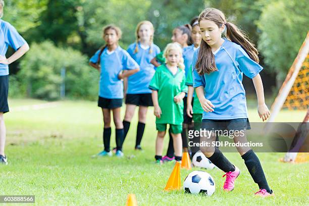 focused preteen soccer player runs through practice drills - african american girl wearing a white shirt stock pictures, royalty-free photos & images