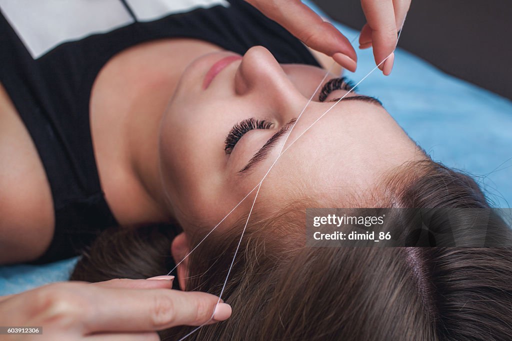 Master in the cabin removes facial hair strand.