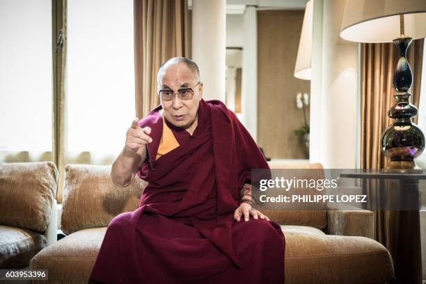 The Dalai Lama gestures during an interview before a press conference at a hotel in Paris on September 13, 2016.