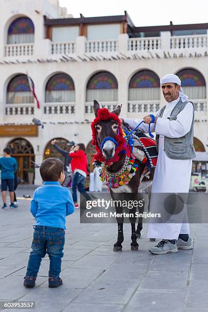 donkey riding kids entertainment in souq - qatar family stock pictures, royalty-free photos & images