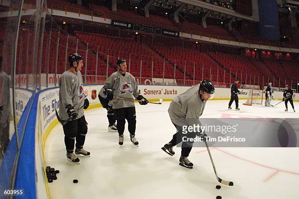 Forward Chris Drury of the Colorado Avalanche, along with Dan Hinote, far left, and defenseman Todd Gil, center, participate in a morning training...