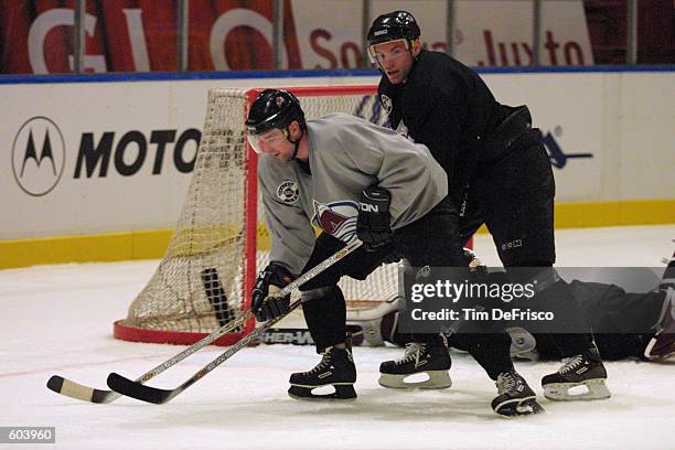 Forward Chris Drury, left, of the Colorado Avalanche gets around defenseman Martin Skoula during the morning training camp session of the 2001 NHL...