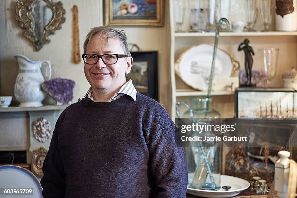 a portrait of a middle aged antique dealer - man in antique shop stock pictures, royalty-free photos & images