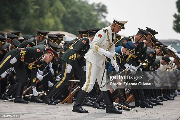 Honour guards pick up their weapon before the welcoming ceremony of Peruvian President outside the Great Hall of the People on September 13, 2016 in...