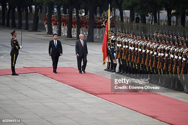 Chinese President Xi Jinping accompanies Peruvian President Pedro Pablo Kuczynski to view an honour guard during a welcoming ceremony outside the...
