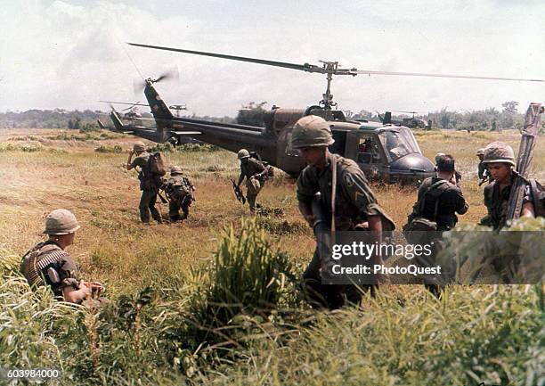 View of American troops from the 173rd Airborne Brigade as they exit a helicopter 40 miles south of Saigon, Vietnam, August 1965.