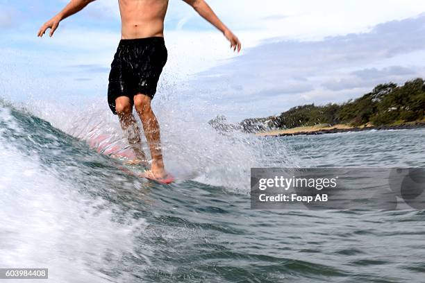 close-up of man surfing on the wave - バンダバーグ ストックフォトと画像