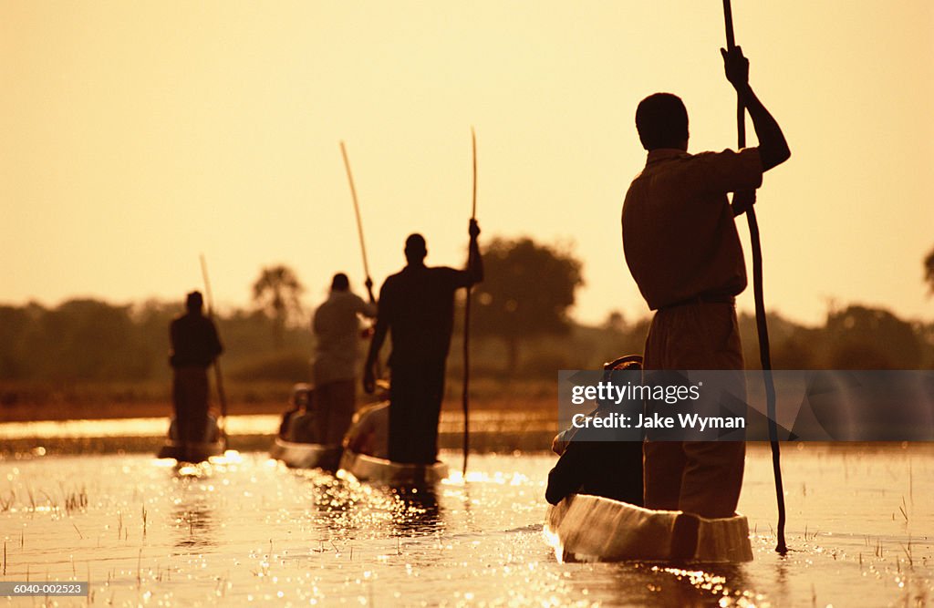 Men Punting Boats along River