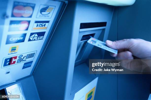 hand putting card into atm - geldautomaat stockfoto's en -beelden