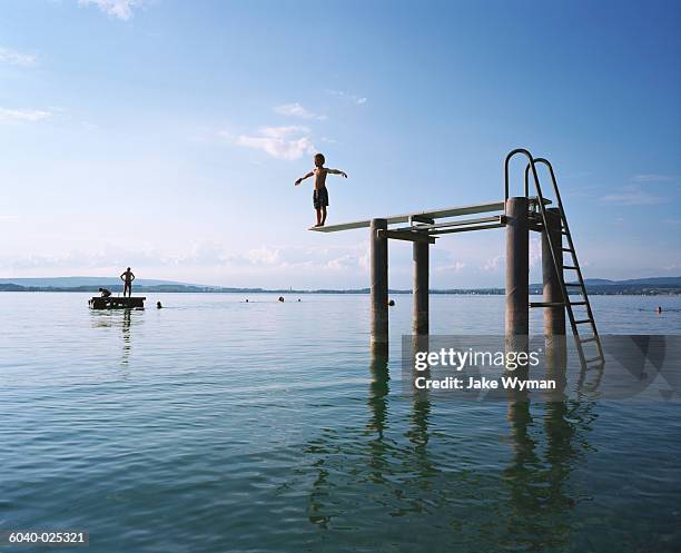 boy about to dive into lake - convictions stockfoto's en -beelden