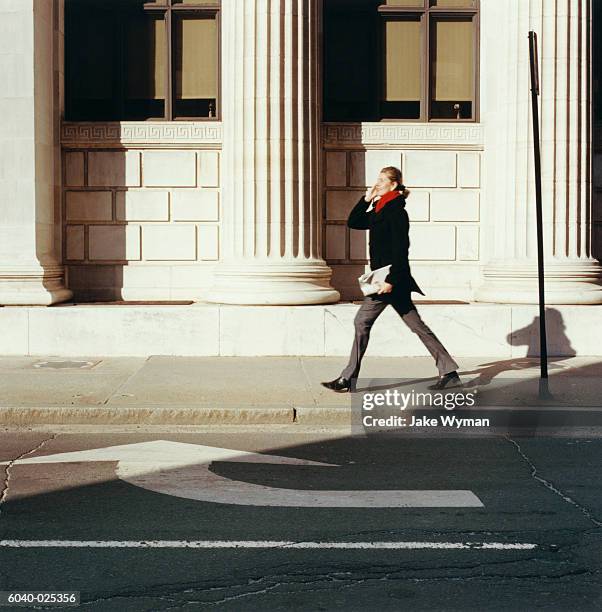 woman walking by columns - business history stock pictures, royalty-free photos & images