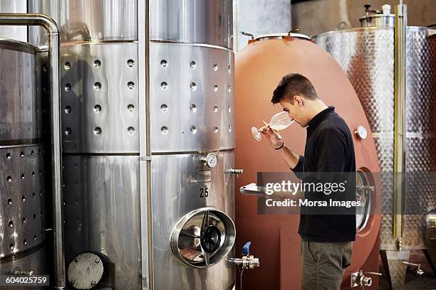 man smelling wine while holding clipboard - wijnbouw stockfoto's en -beelden