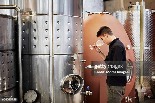 man smelling wine while holding clipboard - viniculture stock pictures, royalty-free photos & images