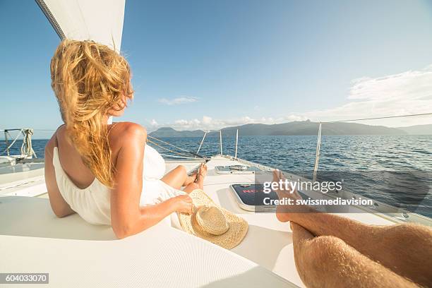 pareja joven relajándose en velero - catamaran fotografías e imágenes de stock