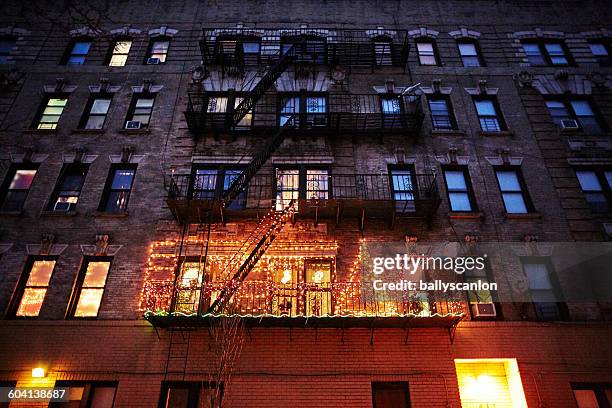 christmas lights on a new york fire escape - christmas newyork stockfoto's en -beelden