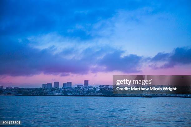 approaching the newport beach coastline at sunset. - newport beach california stock pictures, royalty-free photos & images