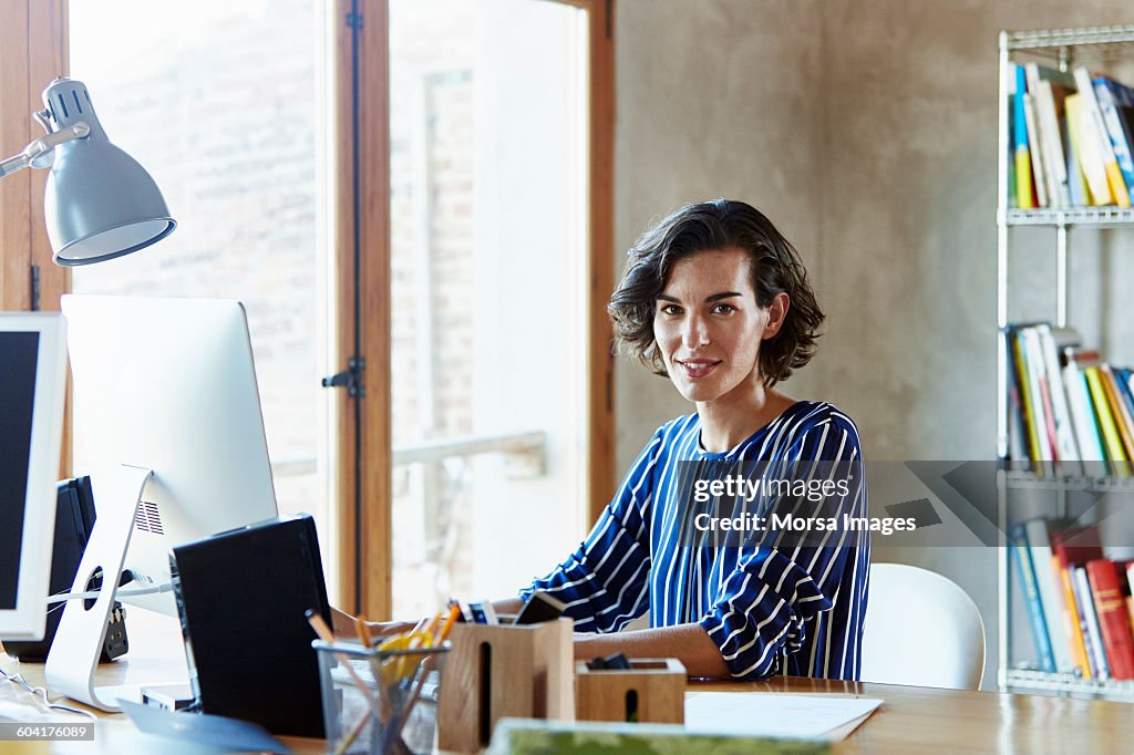 Creative businesswoman sitting at desk in office