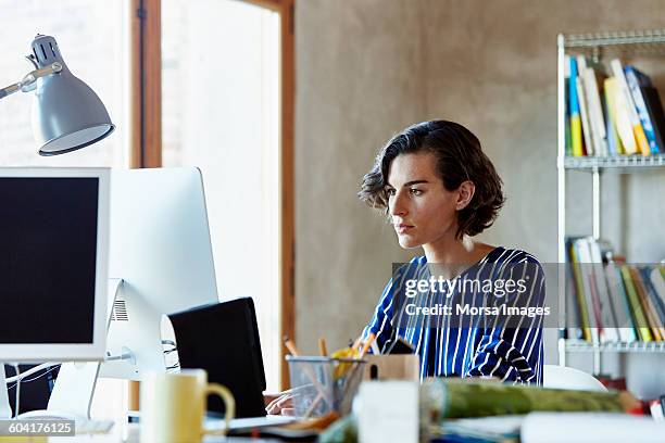 businesswoman using computer in office - leanincollection working women stockfoto's en -beelden