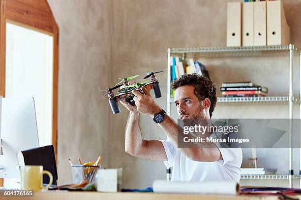 creative businessman making octocopter in office - drones stock pictures, royalty-free photos & images