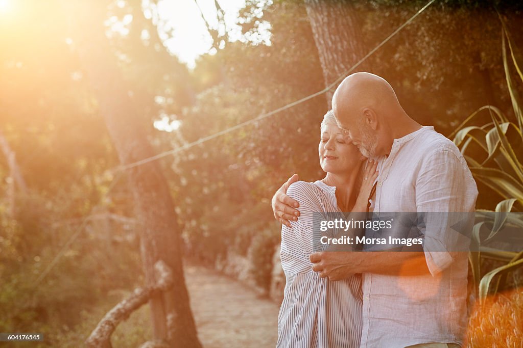 Senior couple embracing each other in forest