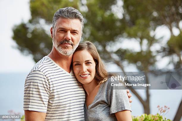 portrait of mature couple smiling - arm around stock pictures, royalty-free photos & images