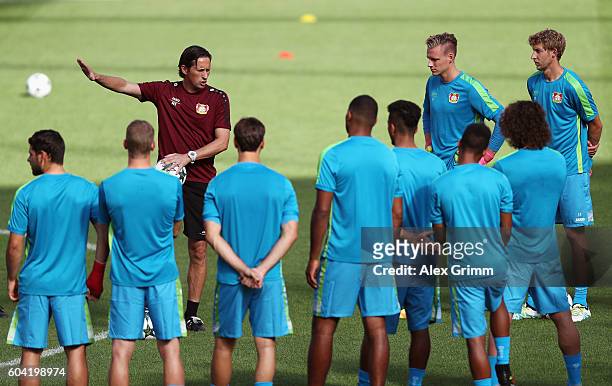 Head coach Roger Schmidt talks to the players during a Bayer Leverkusen training session ahead of their Champions League Group E match against CSKA...