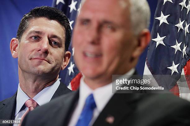 Speaker of the House Paul Ryan listens to U.S. Republican vice presidental nominee Gov. Mike Pence during a news conference following a weekly House...