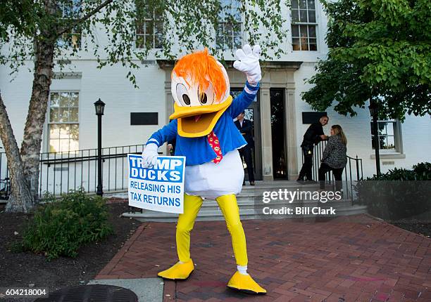 Man in a duck costume waves in front of the Republican National Committee headquarters in Washington as GOP nominee for Vice President Mike Pence...
