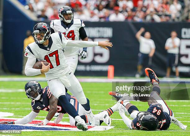 Brock Osweiler of the Houston Texans rushes past Danny Trevathan of the Chicago Bears and Leonard Floyd during a NFL football game at NRG Stadium on...