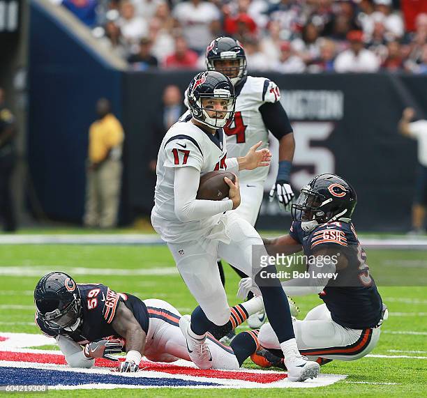 Brock Osweiler of the Houston Texans rushes past Danny Trevathan of the Chicago Bears and Leonard Floyd during a NFL football game at NRG Stadium on...