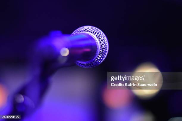close-up of microphone against illuminated stage lights - interview event stock pictures, royalty-free photos & images