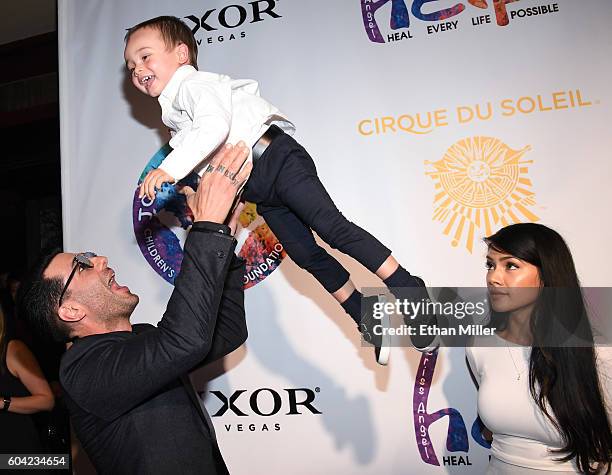 Illusionist Criss Angel tosses his son Johnny Crisstopher Sarantakos in the air as his mother Shaunyl Benson looks on at Criss Angel's HELP charity...