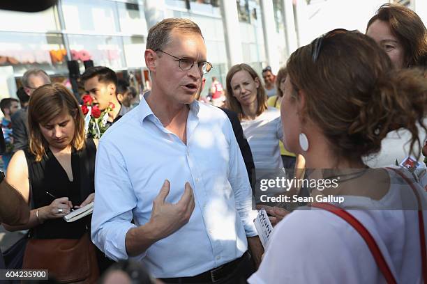 German Social Democrat and current Berlin Mayor Michael Mueller speaks to passersby as he campaigns in Berlin state elections at the Gesundbrunnen...