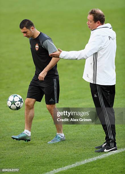 Head coach Leonid Slutski walks past Alan Dzagoev during a CSKA Moskva training session ahead of their UEFA Champions League Group E match against...