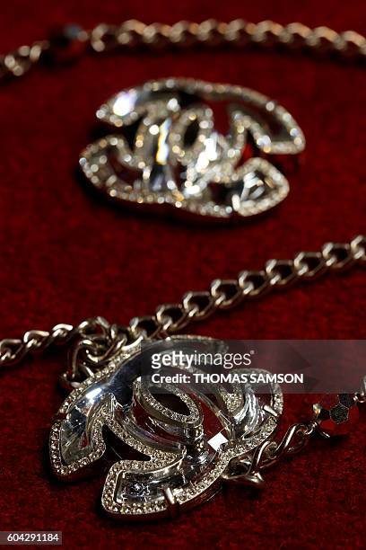 Picture taken on September 13 shows a Chanel vintage brooch and necklace, part of a private collection, displayed ahead of the Hotel Drouot's auction...