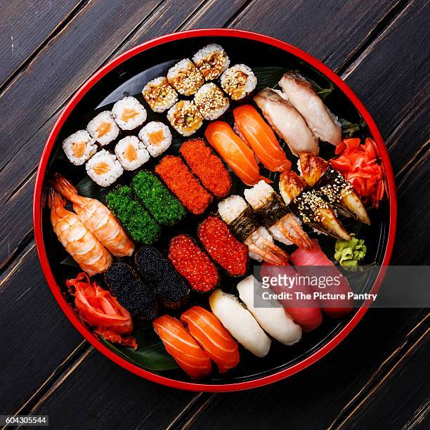 sushi set gunkan, nigiri and rolls served in traditional japan black sushioke round plate - gunkanmaki stock-fotos und bilder