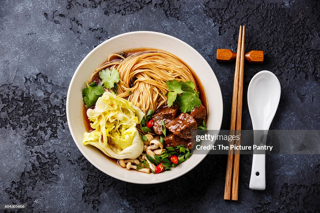 Spicy asian noodles in broth with Beef on dark background