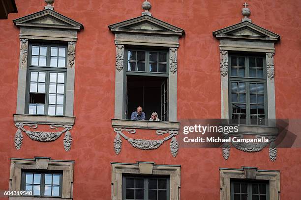 Spectators look out their window and await the arrival of the Swedish king who will attend a ceremony at Storkyrkan in connection with the opening...